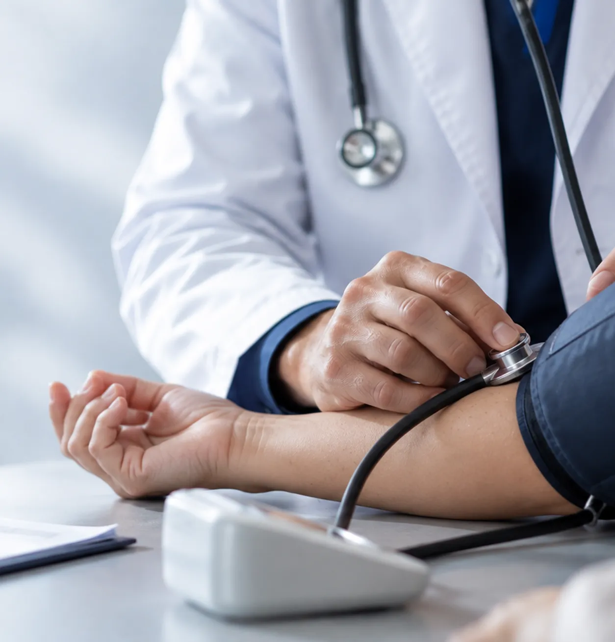 Profesional médico realizando un control de presión arterial durante una consulta clínica.